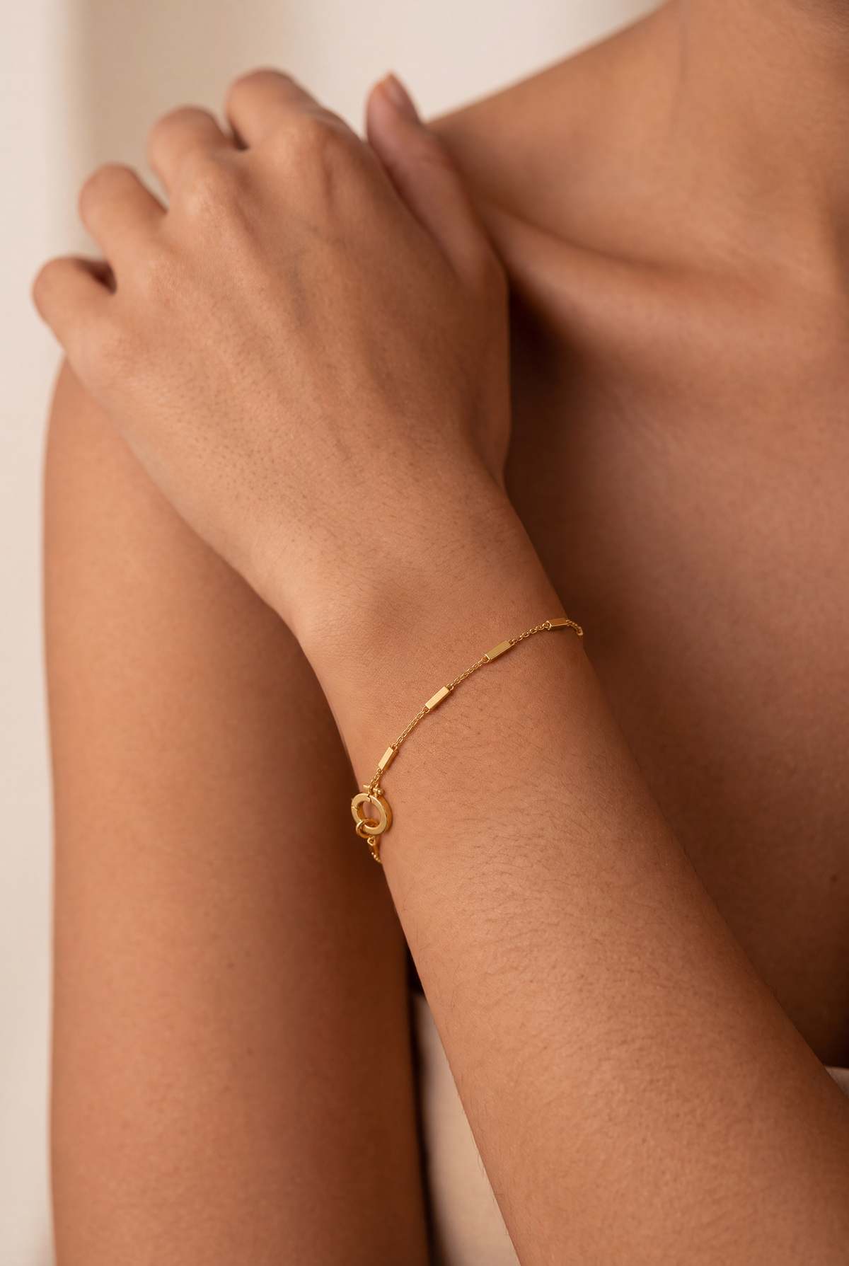 Mini Bar Chain Bracelet Gold worn on a model's wrist, showing rectangular gold bars and the circular clasp.