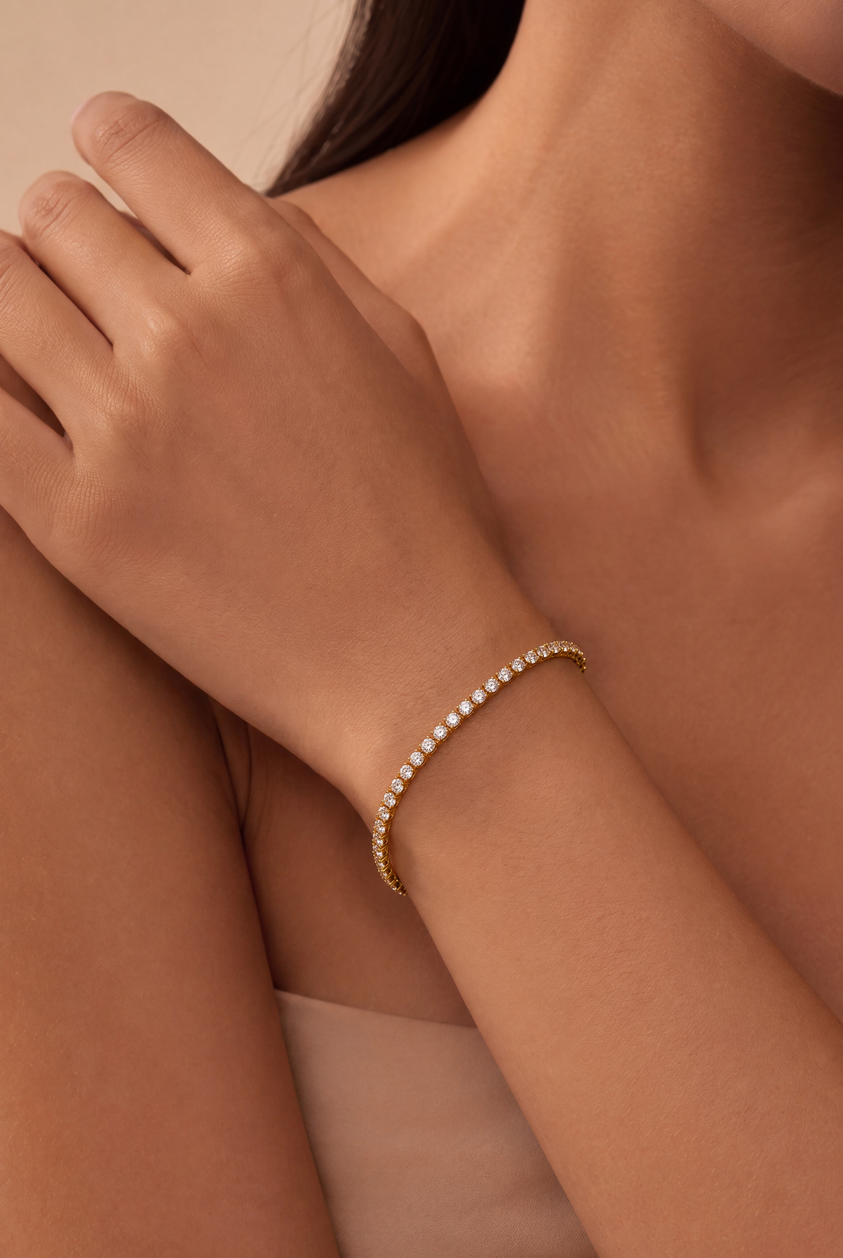White Luster Tennis Bracelet Gold worn on a model's wrist, showing the round white stones and gold setting.