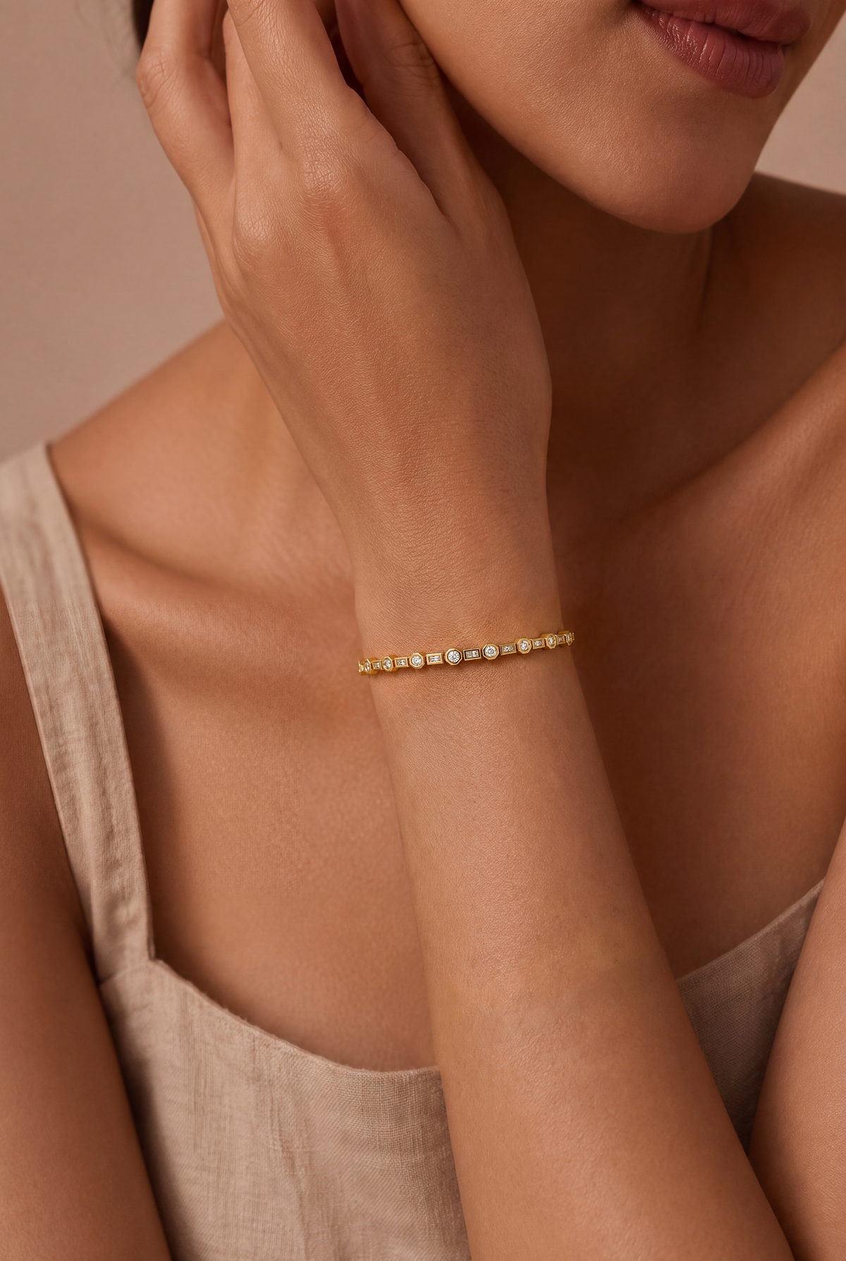 Geo Link Tennis Bracelet Gold worn on a model's wrist, showing alternating round and rectangular stones.