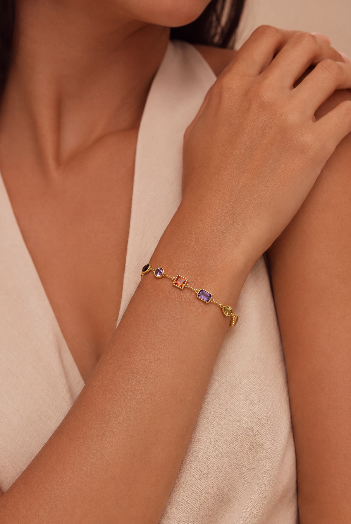Rainbow Stone Bracelet Gold worn on a model's wrist, showing colourful stones on a delicate gold chain.